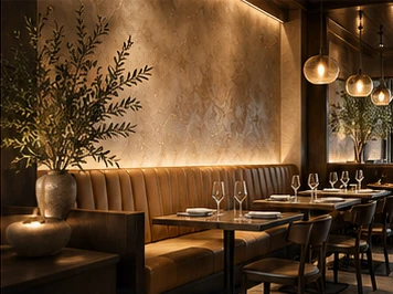 A restaurant with warm plaster walls, banquette seating and pendant lights